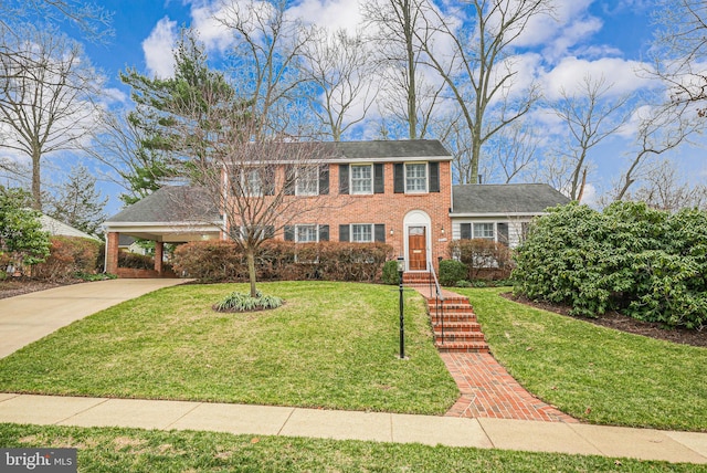 view of front of property featuring an attached carport, concrete driveway, brick siding, and a front lawn