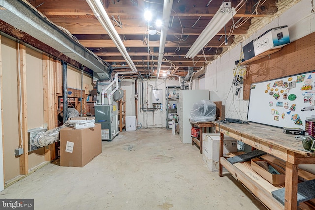 unfinished basement featuring heating unit, a workshop area, and water heater