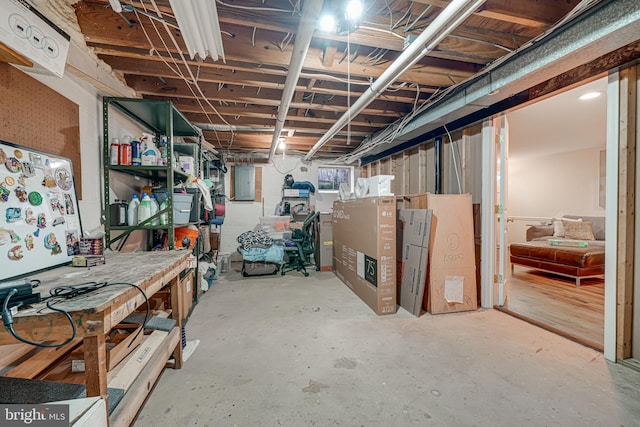 basement with electric panel and a workshop area