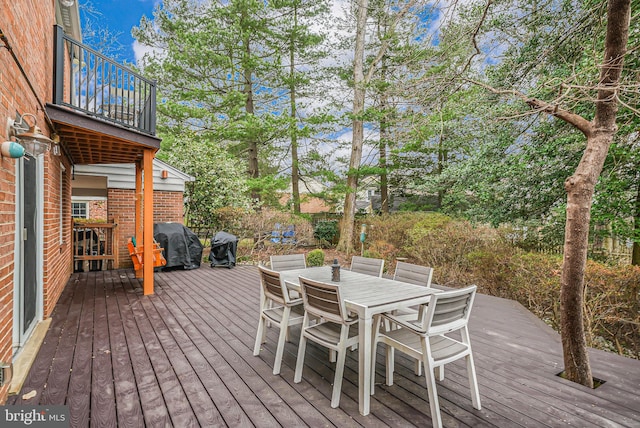 deck featuring outdoor dining area and grilling area