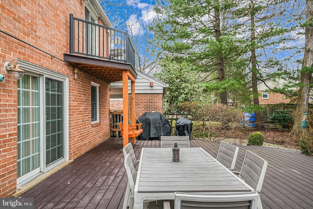 wooden terrace featuring area for grilling and outdoor dining area