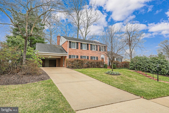 view of front of property with brick siding, a front lawn, a chimney, a carport, and driveway