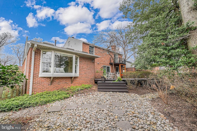 back of property with brick siding and a chimney