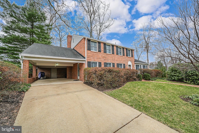 colonial house featuring a chimney, driveway, a front lawn, a carport, and brick siding