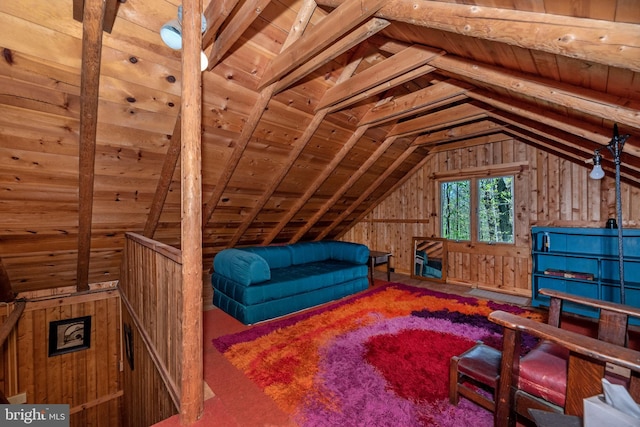 sitting room featuring an upstairs landing, wooden walls, and lofted ceiling