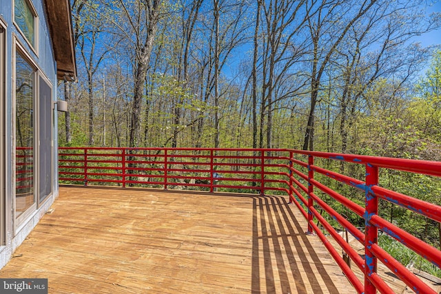 wooden terrace featuring a forest view