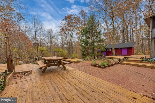 wooden terrace featuring an outdoor structure and outdoor dining space