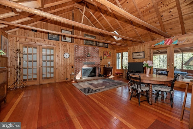 unfurnished dining area featuring hardwood / wood-style floors, french doors, wood walls, and wooden ceiling