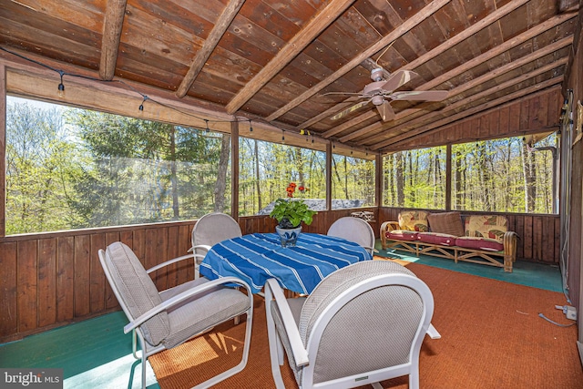 sunroom / solarium featuring lofted ceiling, a ceiling fan, and a wealth of natural light