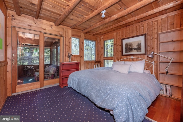 carpeted bedroom with access to exterior, wooden walls, beamed ceiling, and wooden ceiling