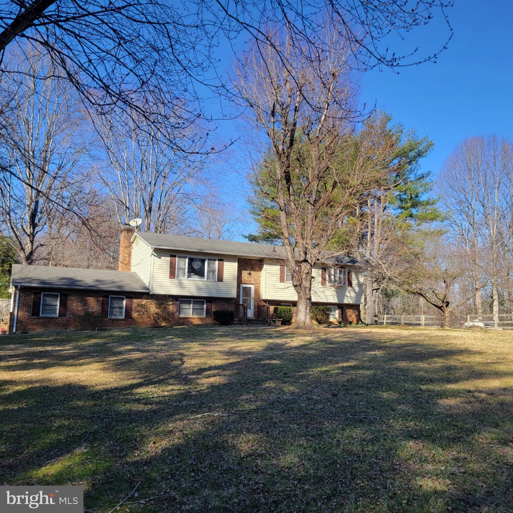 exterior space with a lawn, brick siding, and a chimney