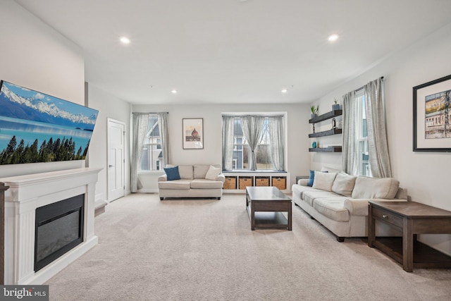 carpeted living area featuring recessed lighting and a glass covered fireplace