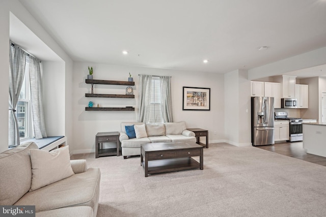 living area with recessed lighting, dark carpet, and baseboards