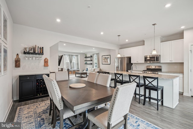 dining area with recessed lighting, baseboards, and light wood finished floors