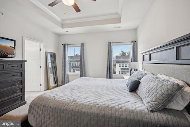 bedroom featuring a raised ceiling, multiple windows, and visible vents