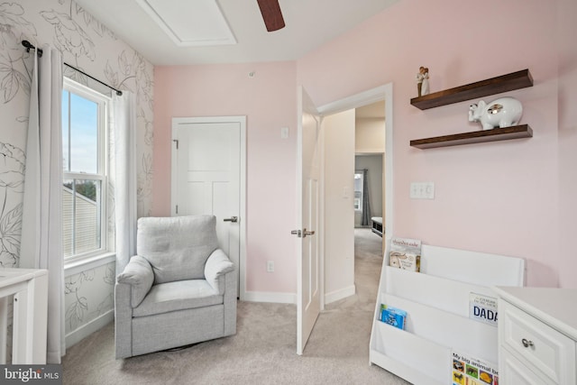 living area featuring light colored carpet and baseboards