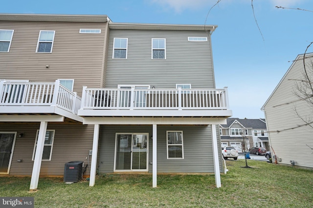 back of property featuring a deck, a lawn, and central AC