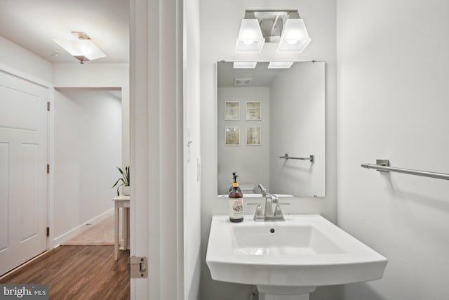 bathroom featuring visible vents, wood finished floors, and a sink