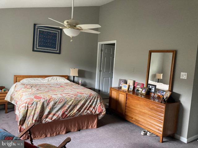 carpeted bedroom with lofted ceiling and a ceiling fan