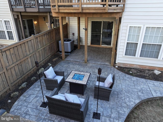 view of patio / terrace featuring an outdoor living space with a fire pit, cooling unit, and fence