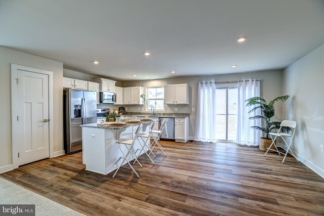 kitchen featuring a center island, recessed lighting, white cabinets, stainless steel appliances, and dark wood-style flooring