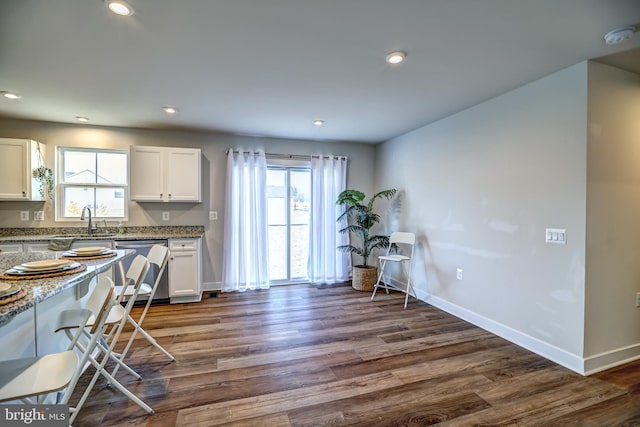 kitchen featuring stainless steel dishwasher, white cabinets, recessed lighting, and dark wood-style flooring