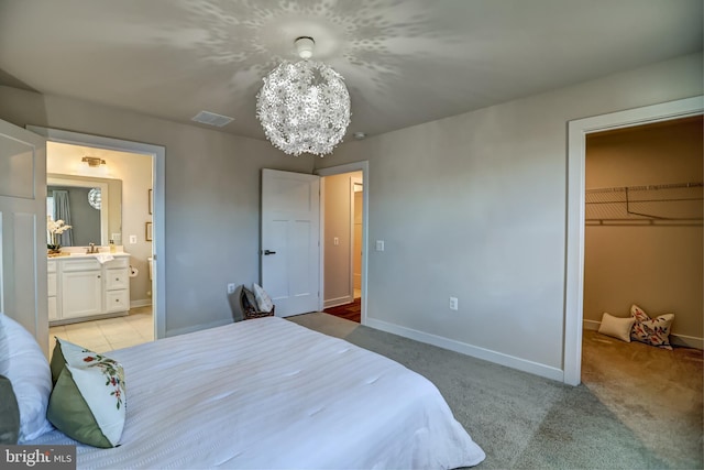 bedroom with visible vents, baseboards, a notable chandelier, and a walk in closet