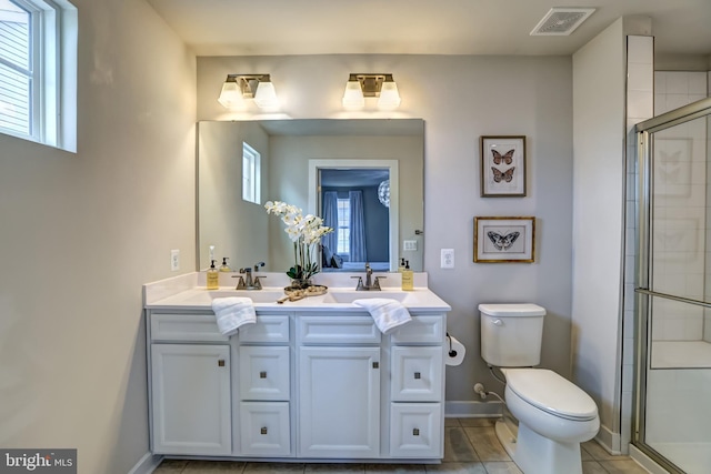 bathroom with a shower stall, toilet, visible vents, and a sink