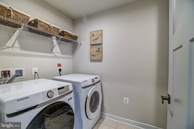 laundry room with light tile patterned floors, baseboards, independent washer and dryer, and laundry area
