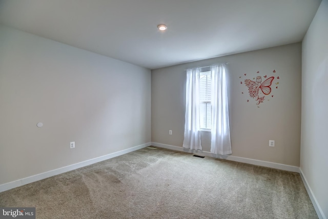 empty room featuring baseboards and carpet