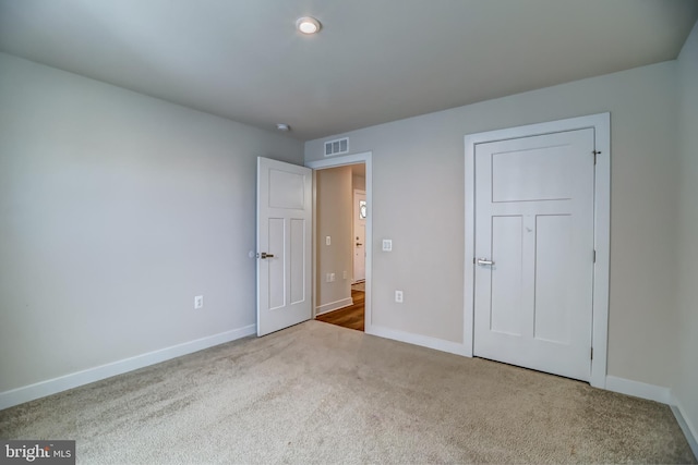 unfurnished bedroom featuring baseboards, visible vents, and carpet floors