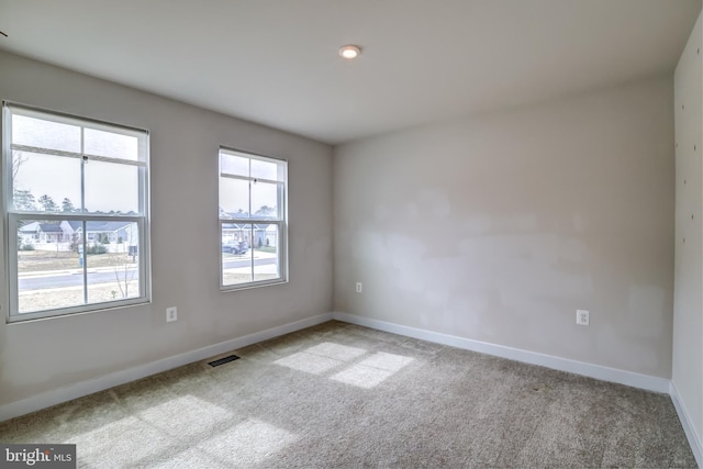 empty room with baseboards, carpet floors, and visible vents