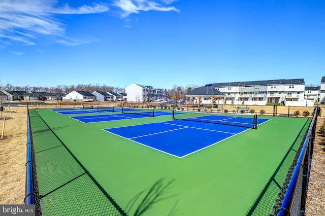 view of sport court with a residential view and fence