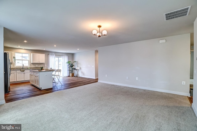 kitchen with visible vents, freestanding refrigerator, open floor plan, white cabinets, and dark colored carpet