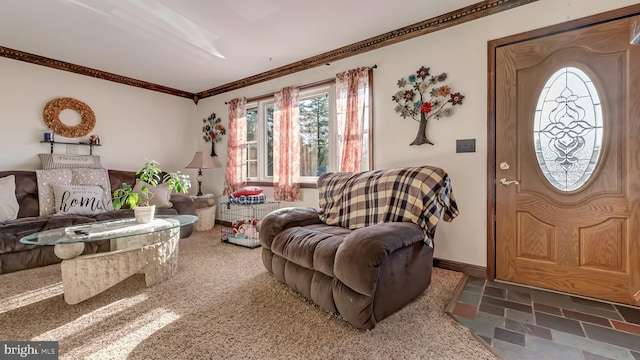 living area featuring crown molding, stone finish floor, and baseboards