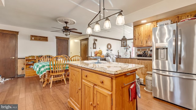 kitchen featuring ceiling fan, a center island, light wood-style flooring, and stainless steel fridge with ice dispenser