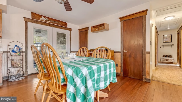 dining space with attic access, light wood-style floors, and ceiling fan