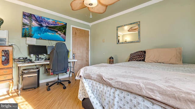 bedroom with ceiling fan, crown molding, baseboards, and wood finished floors