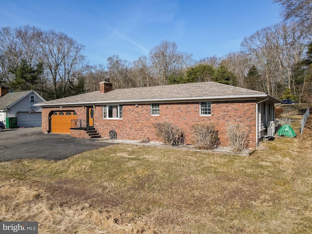 view of side of home with an attached garage, a lawn, brick siding, and a chimney