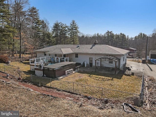 rear view of property featuring a deck, a lawn, fence private yard, and driveway