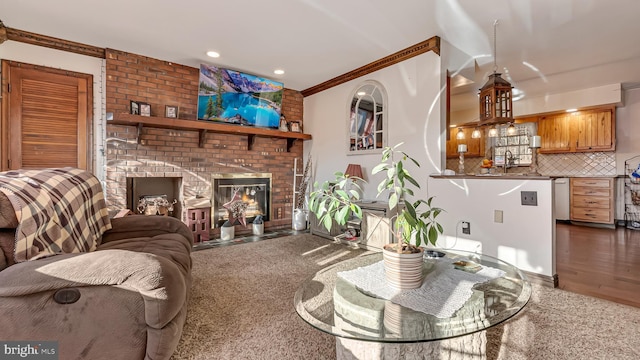 living area with wood finished floors, recessed lighting, a fireplace, and ornamental molding