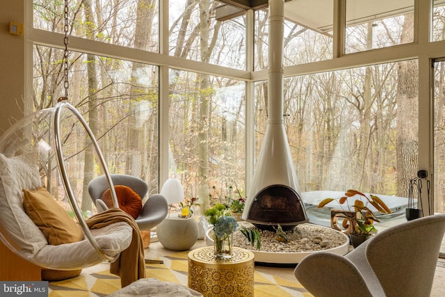 sunroom with a wood stove and a wealth of natural light