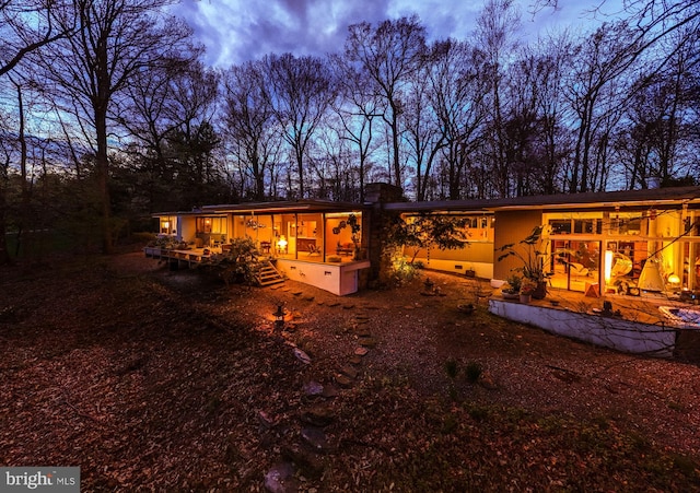 back of house at dusk with a chimney