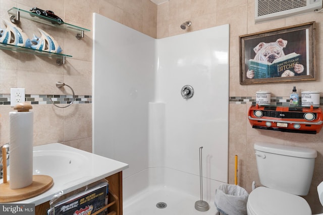 bathroom featuring a shower stall, vanity, tile walls, toilet, and a wall unit AC