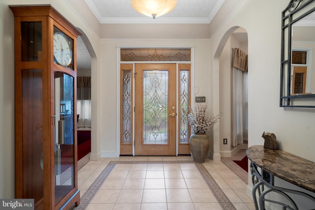 entrance foyer featuring baseboards, arched walkways, and light tile patterned floors