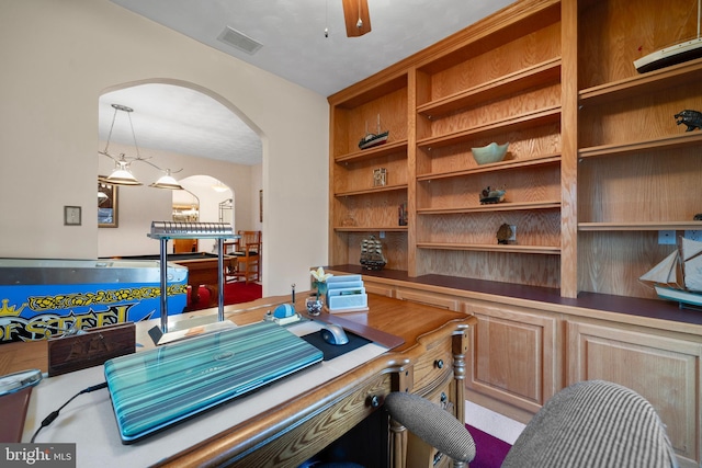 office featuring ceiling fan, arched walkways, and visible vents