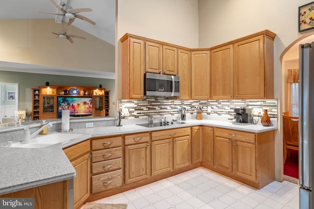 kitchen featuring high vaulted ceiling, a ceiling fan, a sink, black electric stovetop, and stainless steel microwave