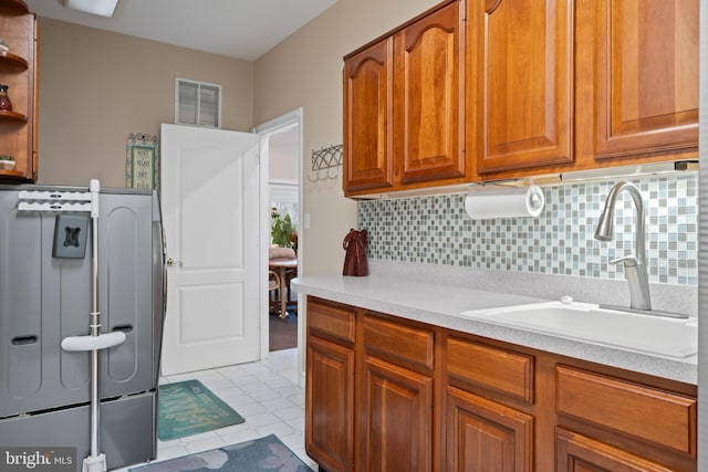 clothes washing area featuring visible vents, a sink, laundry area, and light tile patterned flooring
