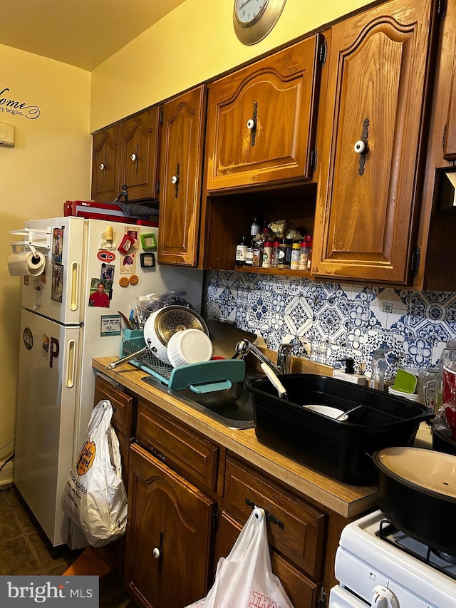 2834 Edgecombe Cir S, Baltimore, MD 21215 - kitchen with white range with gas cooktop, dark tile patterned floors, tasteful backsplash, and light countertops