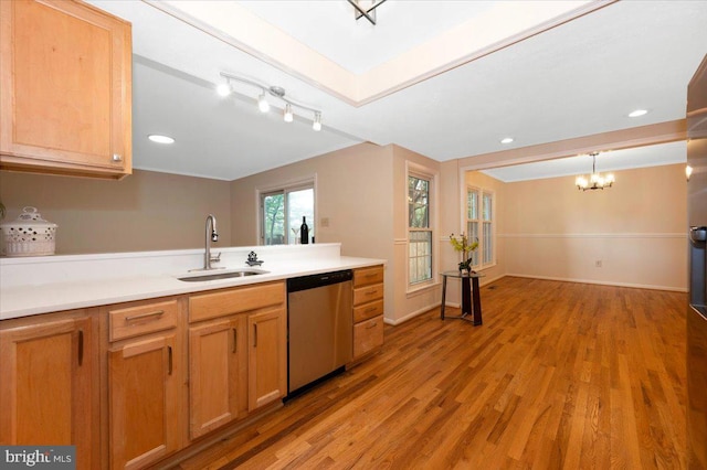 kitchen with stainless steel dishwasher, a sink, a chandelier, light wood finished floors, and light countertops